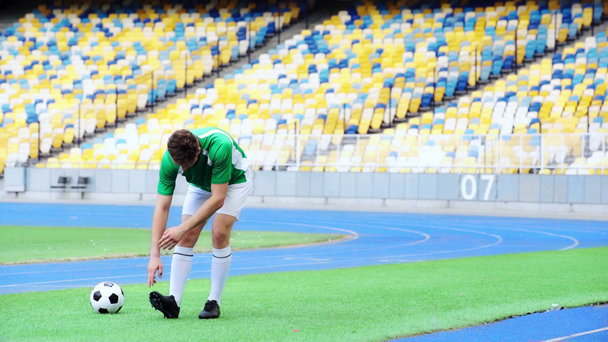 piłkarz rozciągający nogi na stadionie  - Materiał filmowy, wideo