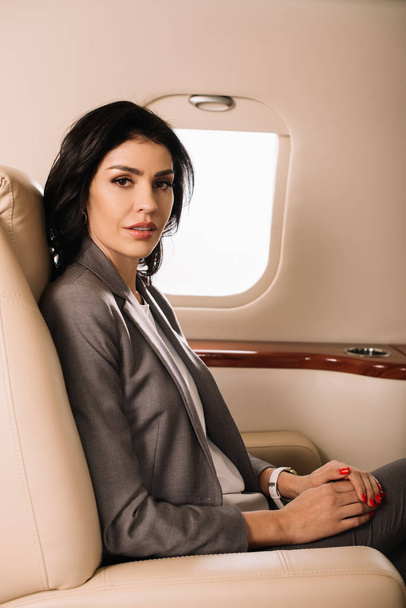 beautiful businesswoman sitting in private jet  - Zdjęcie, obraz