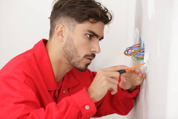 a man during repair of an electricity socket - Foto, Imagen