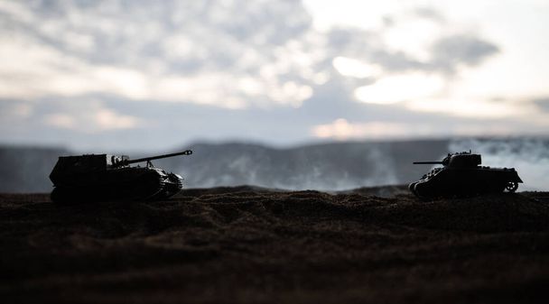 Concepto de guerra. Siluetas militares que luchan escena en el fondo del cielo niebla de guerra, Guerra Mundial tanques alemanes siluetas debajo del horizonte nublado Por la noche. Escena de ataque
. - Foto, imagen