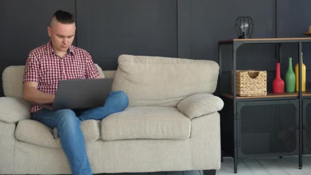 Hombre guapo está escribiendo texto en el ordenador portátil gris
 - Metraje, vídeo