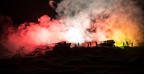 Πολεμική ιδέα. Στρατιωτικές σιλουέτες αγωνίζονται σκηνή στον πόλεμο ομίχλη ουρανό φόντο, παγκόσμιος πόλεμος Γερμανικά άρματα φιγούρες κάτω από συννεφιασμένο ορίζοντα τη νύχτα. Σκηνή επίθεσης. Τεθωρακισμένα οχήματα και πεζικό. - Φωτογραφία, εικόνα