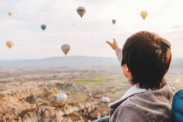 Azji człowiek oglądanie kolorowe balony na ogrzane powietrze latające nad val - Zdjęcie, obraz
