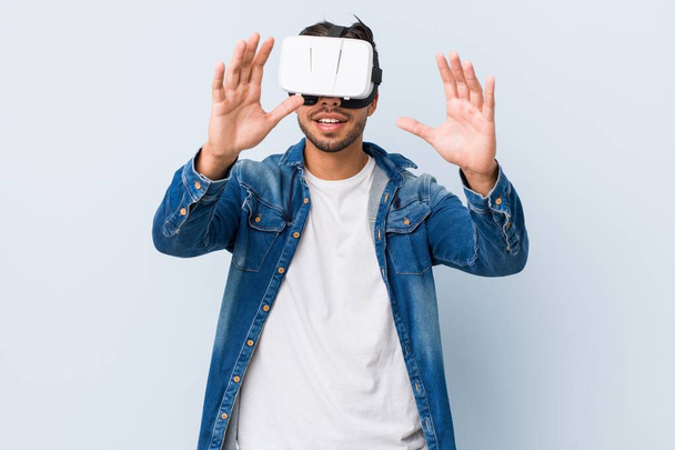 Jovem sul-asiático homem jogando com virtual realidade óculos
 - Foto, Imagem