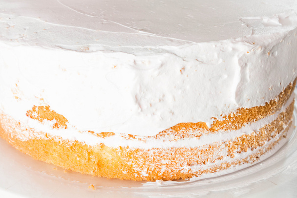 vanille spons cake versieren met slagroom - Foto, afbeelding