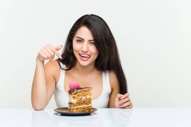 Νεαρή ισπανίδα γυναίκα τρώει ένα κέικ καρότο - Φωτογραφία, εικόνα