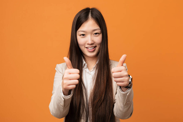 親指アップと若いビジネス中国の女性,何かについての歓声,サポートと尊敬の概念. - 写真・画像