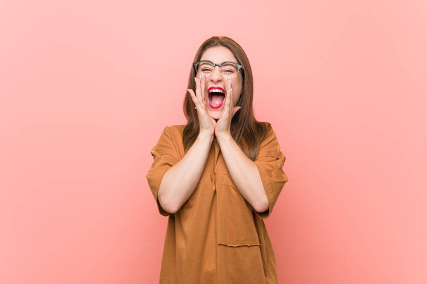 Young student woman wearing eyeglasses shouting excited to front. - 写真・画像