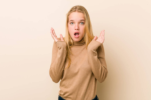 Cute and natural teenager woman surprised and shocked. - 写真・画像