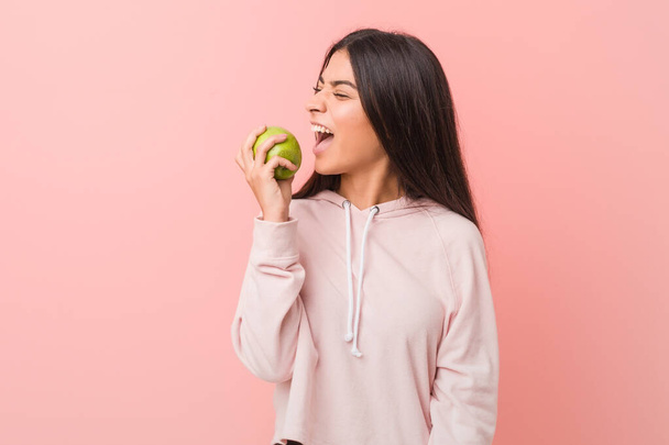 young girl posing with green apple on pink background  - Valokuva, kuva