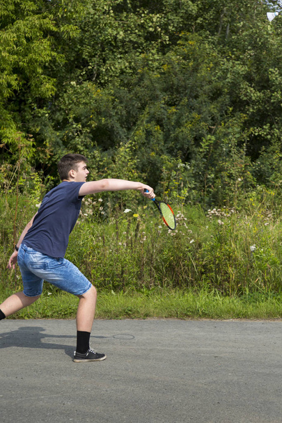 Elinde raket olan genç bir çocuk badminton oynar. - Fotoğraf, Görsel