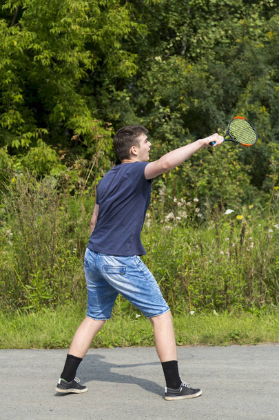 Jeune garçon avec une raquette dans la main joue au badminton
 - Photo, image