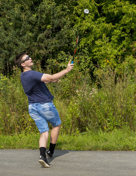 Подросток с ракеткой в руке играет в бадминтон
 - Фото, изображение