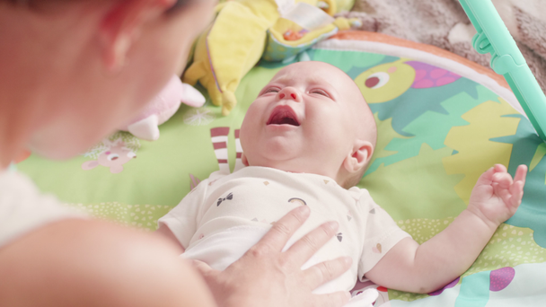 Mutter beruhigt weinende neugeborene Tochter.Mutter mit ihrer neugeborenen Tochter im Alter von zwei Monaten - Filmmaterial, Video