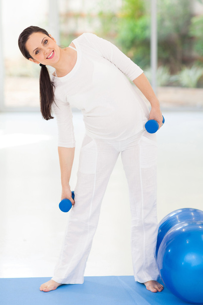 young pregnant woman working out with dumbbells - Valokuva, kuva