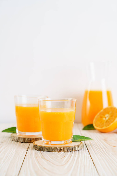 Fresh orange juice on wood background - Valokuva, kuva