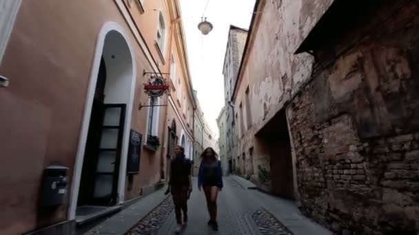 Spacer starożytnymi uliczkami europejskiego miasta. Dwie młode kobiety spacerujące wąskimi uliczkami starego miasta w Wilnie. Dwie młode kobiety spacerują po starym mieście w Wilnie. - Materiał filmowy, wideo