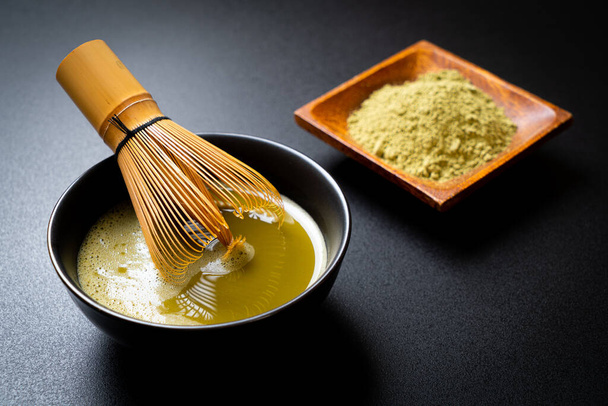 hot matcha green tea cup with green tea powder and whisk - 写真・画像