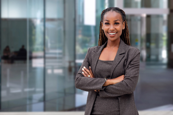 Happy African American mujer líder de la compañía CEO jefe ejecutivo de pie frente a la construcción de la empresa
 - Foto, Imagen