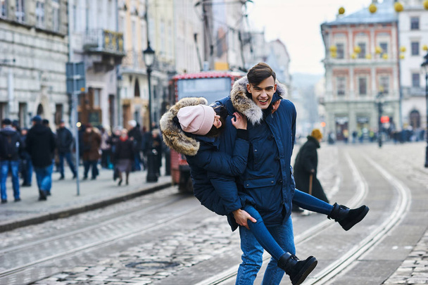 A trendy young couple walks in the city at christmastime - 写真・画像