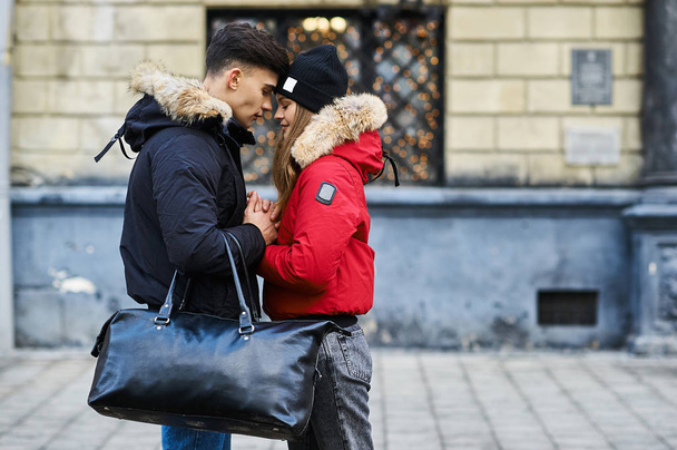 A trendy young couple walks in the city at christmastime - 写真・画像
