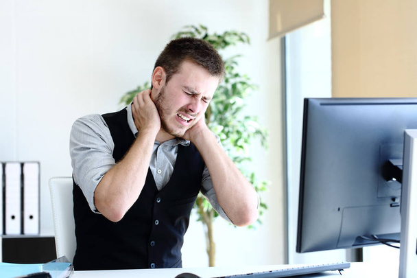 Młody dyrektor cierpi ból szyi w biurze - Zdjęcie, obraz