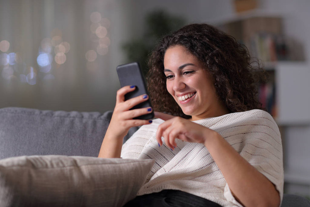 Happy arab woman using smart phone in the night - 写真・画像