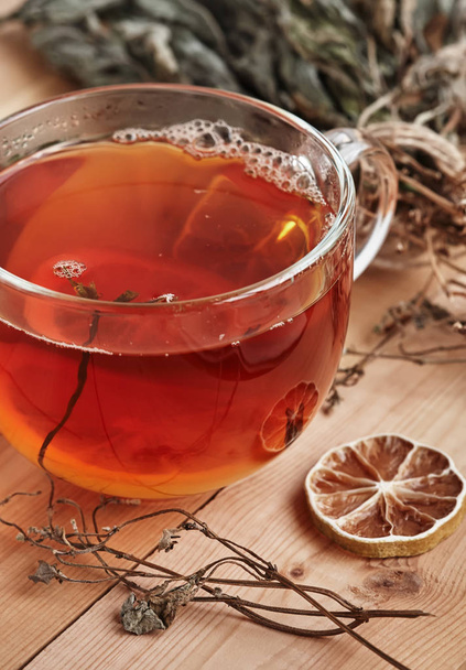 Μαύρο τσάι με φέτα λεμόνι σε γυάλινο κύπελλο. - Φωτογραφία, εικόνα