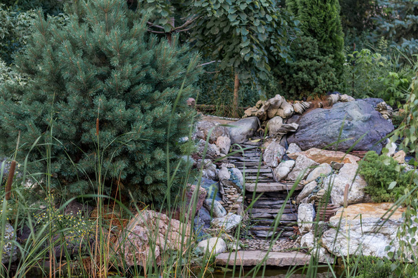 池の岸に石や葦で作られた人工的なスライドは - 写真・画像