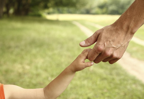  padre sostiene la mano de un niño pequeño - Foto, imagen