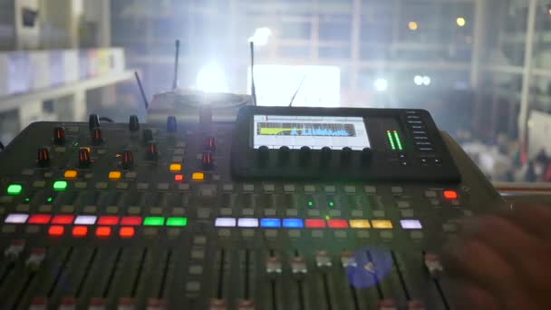 man dj speelt muziek op mengen console close-up op wazig achtergrond met lichten in slow motion - Video