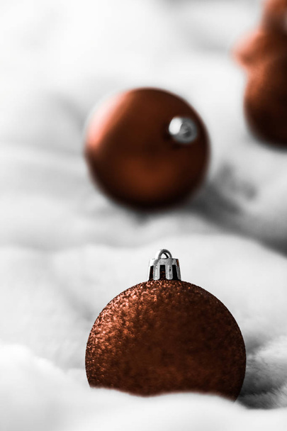 Chocolate brown Christmas baubles on white fluffy fur backdrop,  - Fotoğraf, Görsel