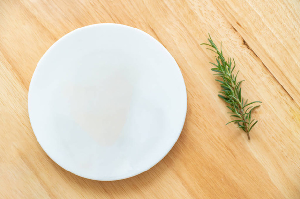 empty plate and rosemary on wooden table - Фото, зображення