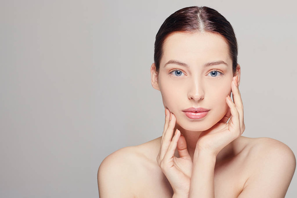 woman with fresh clean skin that touches her face with both hands. Looking straight. Spa, cosmetology and beauty. - Valokuva, kuva