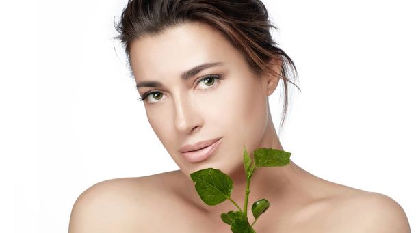 Beleza natural rosto mulher pele saudável com folhas verdes frescas. Conceito de cuidados orgânicos e bio pele
 - Foto, Imagem