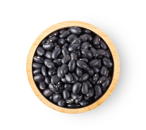 černé fazole v dřevěné míse izolované na bílém pozadí. pohled shora - Fotografie, Obrázek