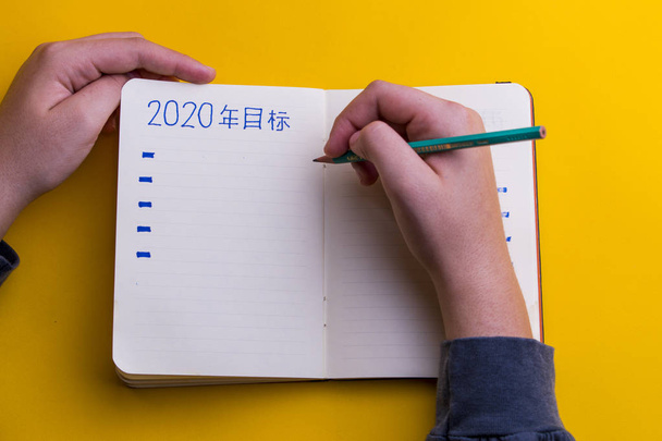 Руки женщины пишут в дневнике новогодние обещания
. - Фото, изображение