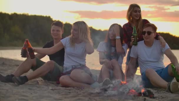 The great party around bonfire with orange sky - Footage, Video