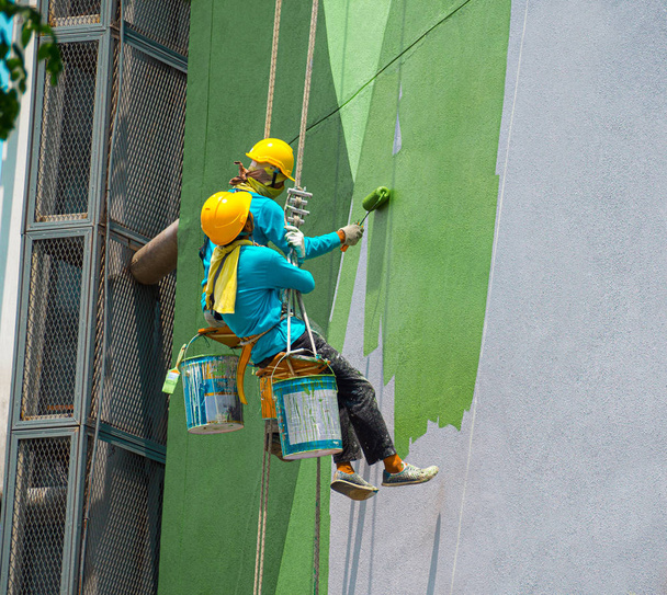Painters painting exterior of building - 写真・画像