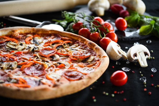 sabrosa pizza italiana capriciosa con ingredientes frescos - verduras, queso, jamón, salsa de tomates y albahaca
 - Foto, Imagen