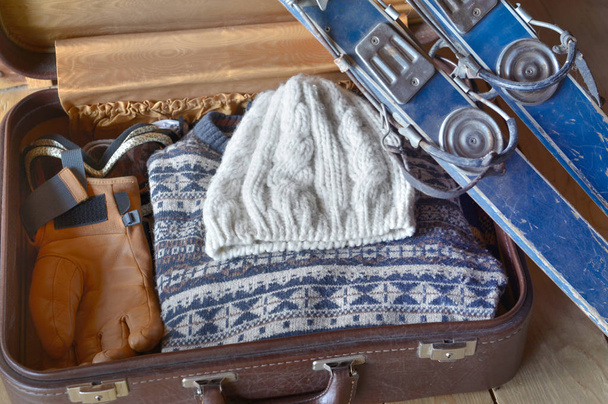 старі лижі на валізі з теплим одягом
 - Фото, зображення