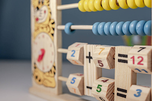 Children's wooden game to learn the hours of a clock and simple math of addition, subtraction, multiplication and division, called abacus - Photo, Image
