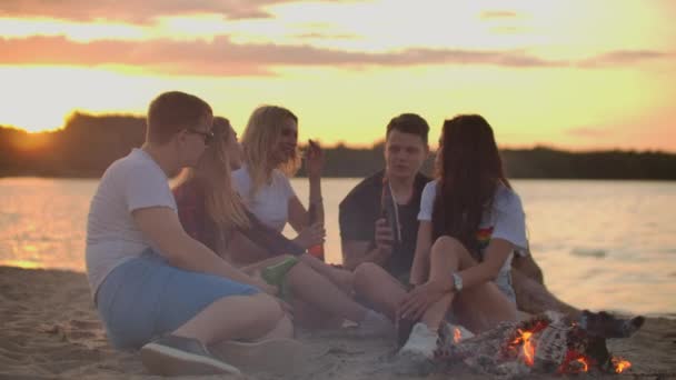 A cég élvezi a meleg nyári estét a homokos tengerparton - Felvétel, videó