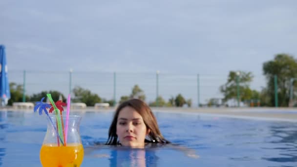 girl drink colorful cocktail and giving thumbs up at Poolside on background sky in Summer vacation - Felvétel, videó