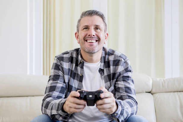 Caucasian man playing video games at home - Foto, afbeelding