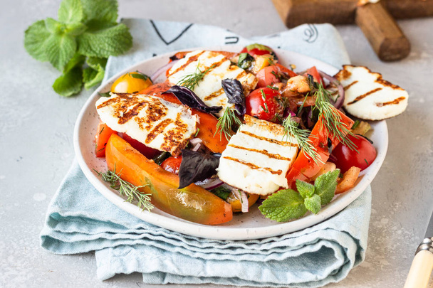 Tomato, baked pepper and onion salad with grilled haloumi cheese (halloumi). Keto diet, healthy food. - 写真・画像