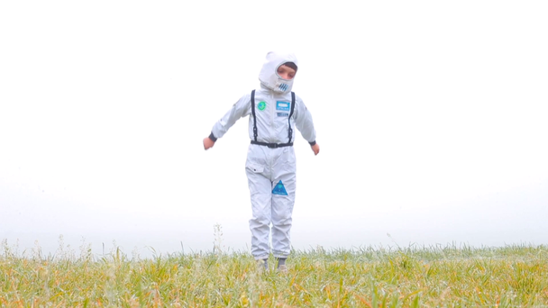Een jongen in een astronaut kostuum poseren, springen op de plek. - Video