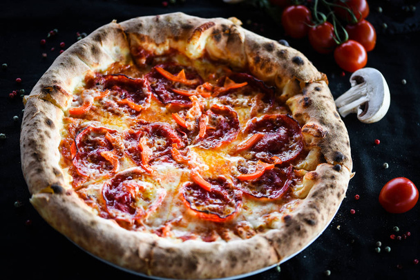 Italiaanse pizza met peperoni & salami in een deeg met dubbele parmezaanse kaas  - Foto, afbeelding