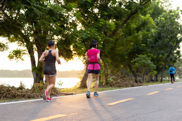 Дві жінки-друзі бігають у парку зі сходом сонця
. - Фото, зображення