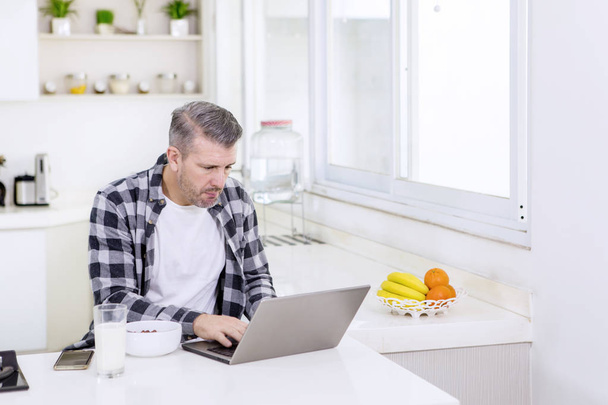 Freelancer working with a laptop during breakfast - Zdjęcie, obraz
